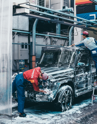 hand washing a car with an orange rag