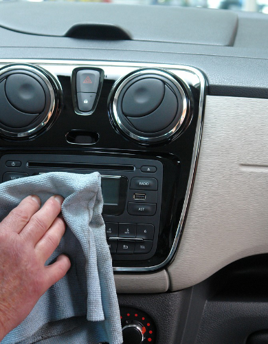 hand washing a car with an orange rag