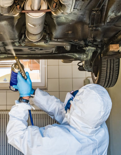 underside of a car being cleaned while its on a lift